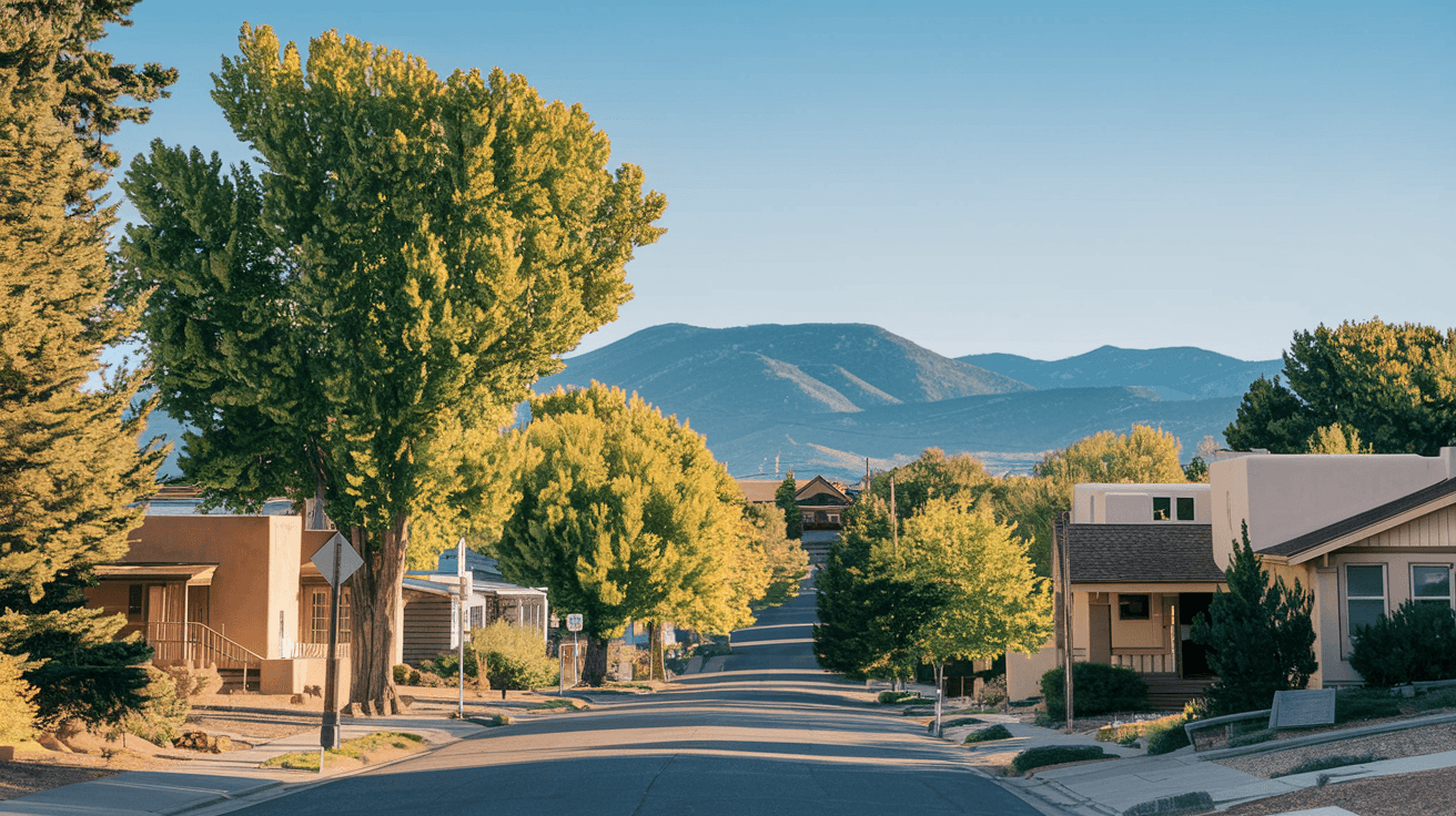 A quiet residential street in Nob Hill, Albuquerque, lined with mature cottonwood trees casting dappled morning light on adobe and Craftsman bungalows, with the Sandia Mountains rising in the distance under a clear blue sky